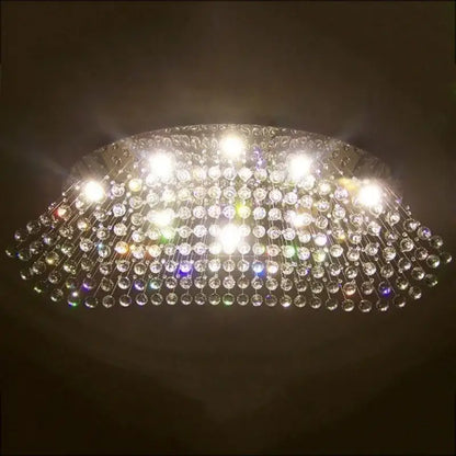 Modern oval crystal flush mount chandelier with clear crystal beads and metallic frame for dining room lighting