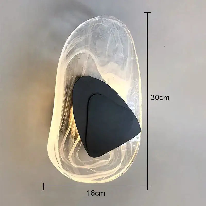 Modern oval crystal wall lamp with transparent body and black triangular accent, ideal as a bedroom crystal wall lamp