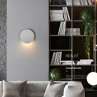 Minimalist white circular led wall lamp emitting warm glow suitable for modern oval gray waterproof garden lighting