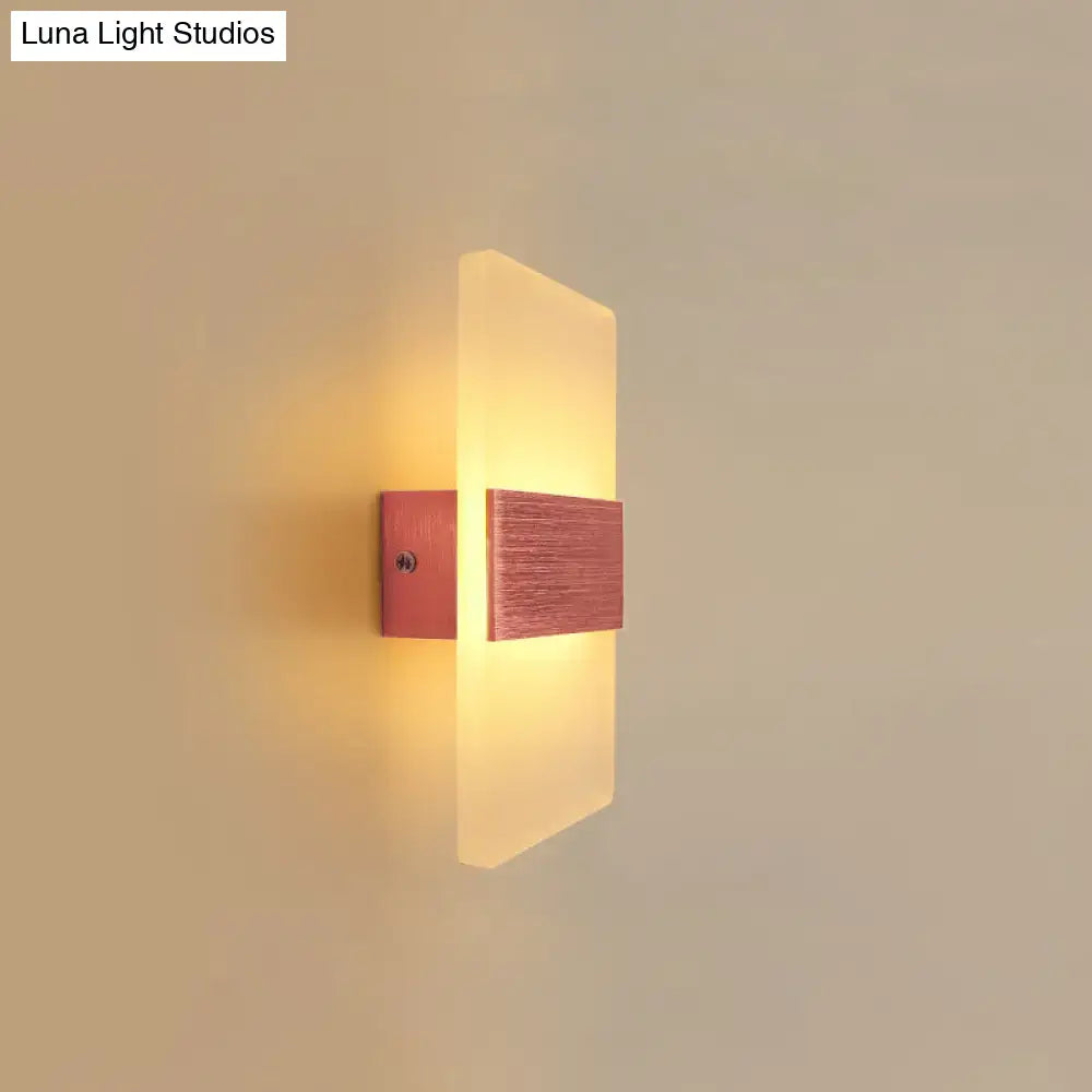Modern oval rectangular convex led wall sconce with frosted glass and brushed copper accents emitting warm amber glow