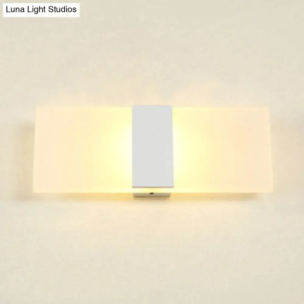 Modern oval rectangular convex led wall sconce with central silver metallic strip and frosted glass panels emitting warm light