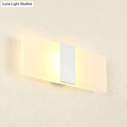 Modern oval rectangular convex wall sconce with frosted glass diffuser and metallic accent emitting warm ambient light