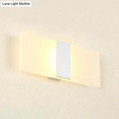 Modern oval rectangular convex wall sconce with frosted glass diffuser and metallic accent emitting warm ambient light