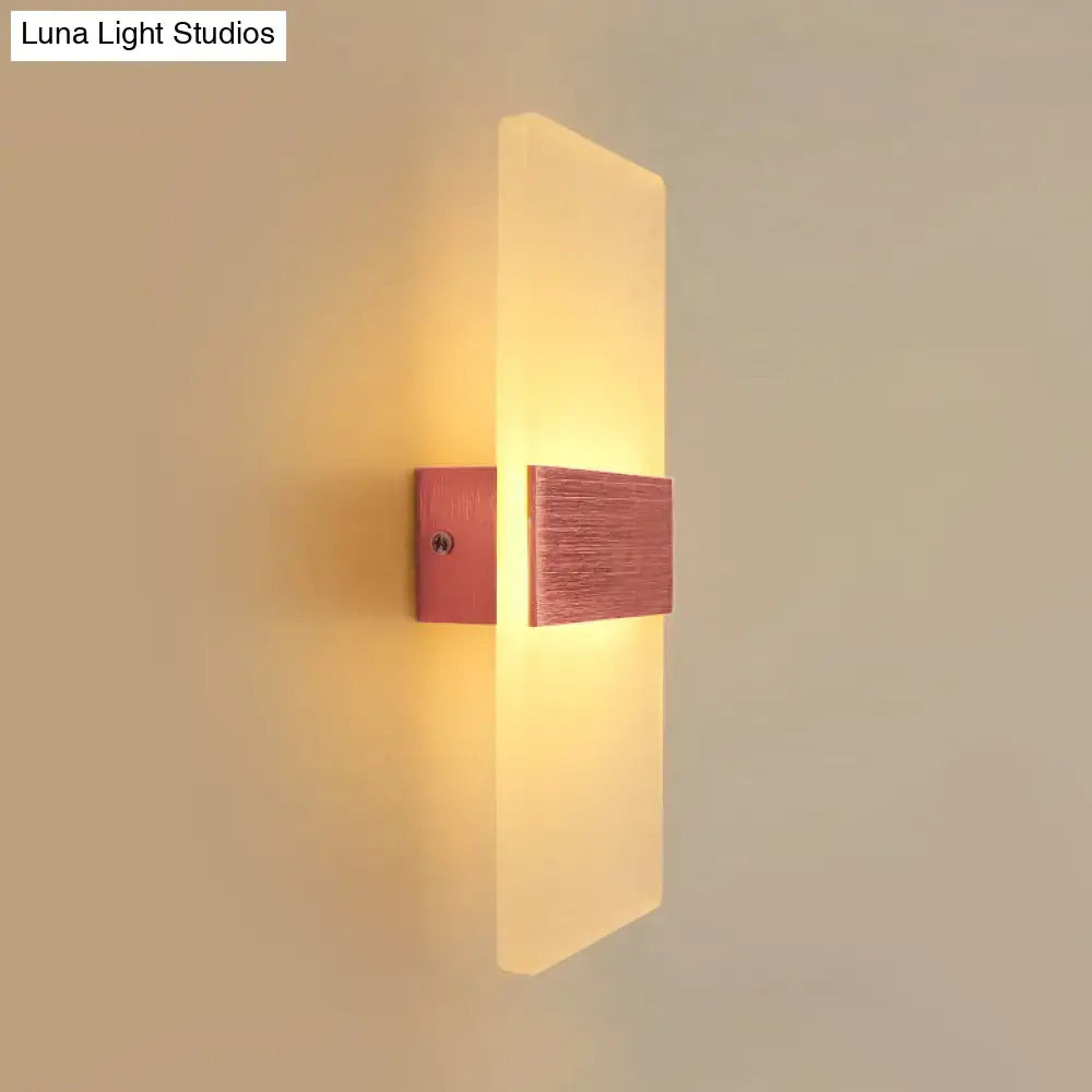 Modern oval rectangular convex led wall sconce with brushed copper base and frosted glass diffuser emitting warm amber glow