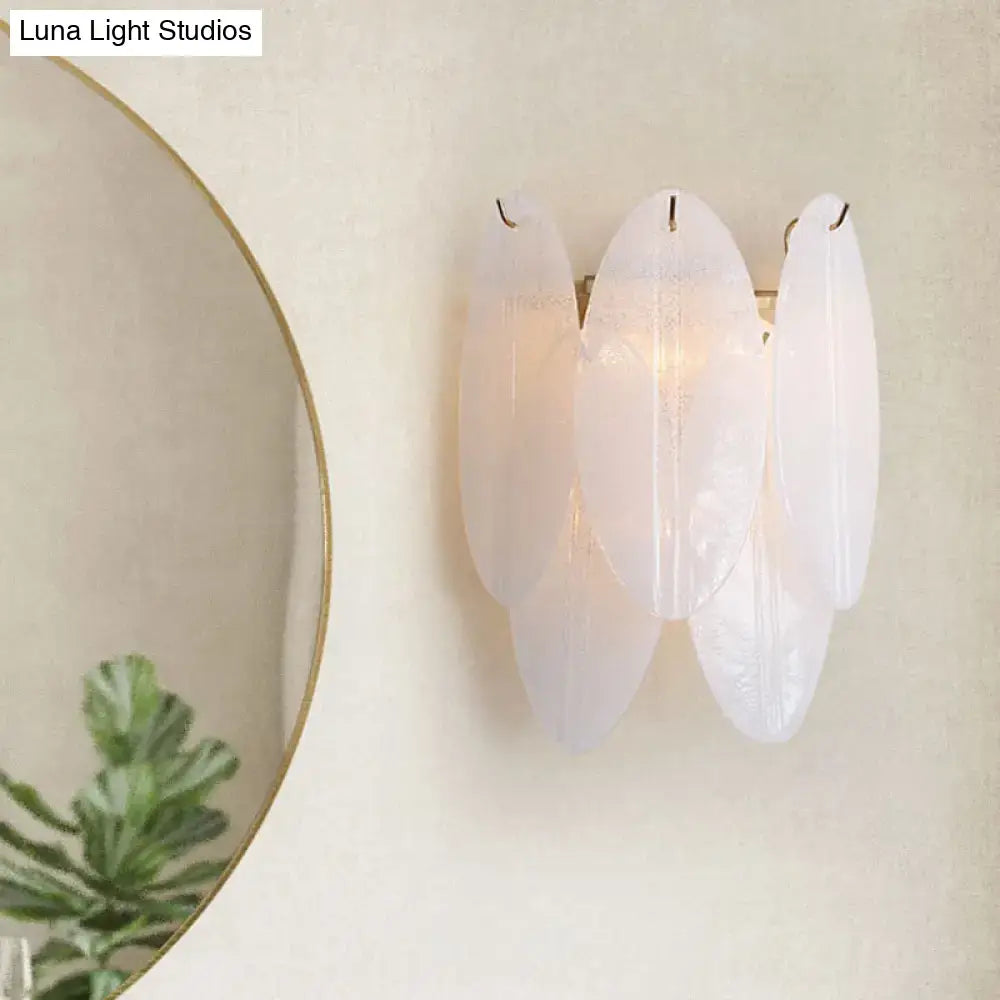 Elegant modern oval white glass wall sconce with frosted finish designed as a hallway light source