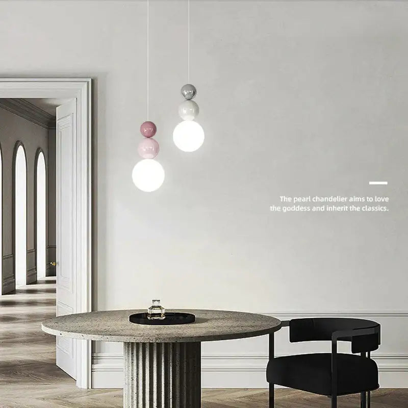 Modern pendant light with three spherical bulbs in matte white soft pink and metallic silver light color options for dining room