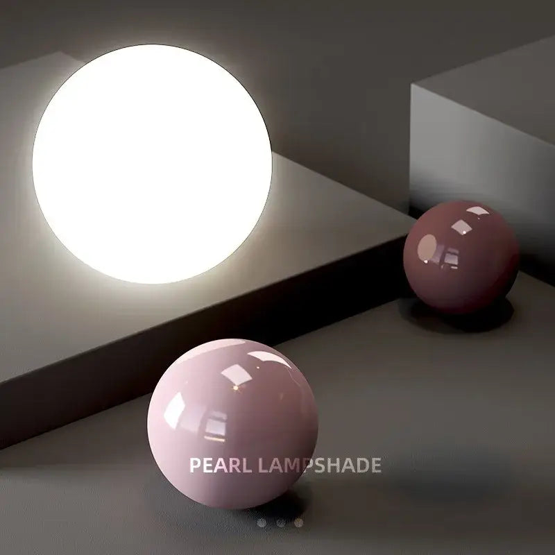 A glowing white spherical pendant light with smooth finish and pastel pink spheres showcases modern light color options