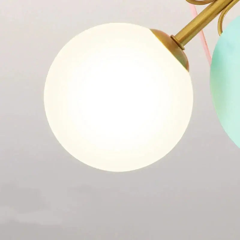 A glowing white spherical glass ceiling light fixture with brass detailing for modern kids bedroom decor