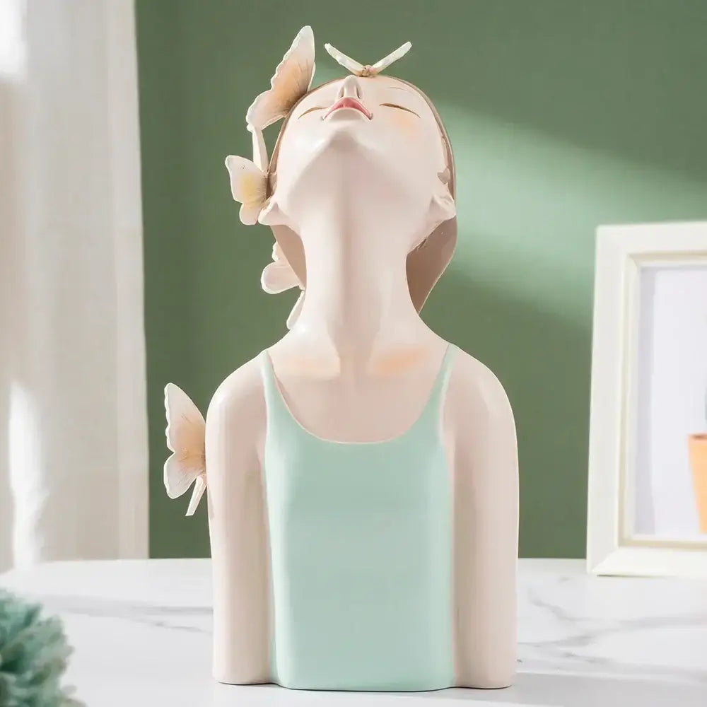 A serene ceramic butterfly girl sculpture in a mint green tank top with pastel butterflies for bedroom decor