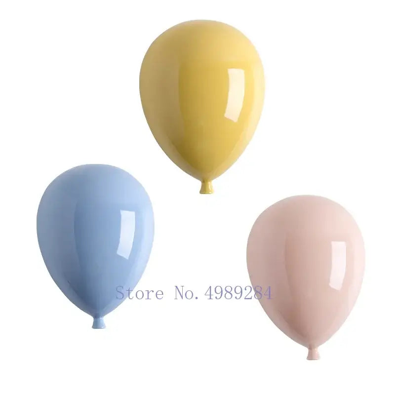 Set of three glossy pastel ceramic balloon wall hanging decorations in yellow blue and pink for children room