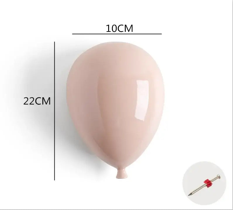 A sleek blush-pink ceramic balloon wall hanging decoration for children room with glossy finish