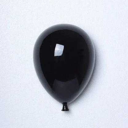 Glossy black ceramic balloon wall hanging decoration with reflective surface and tapered nozzle for children room