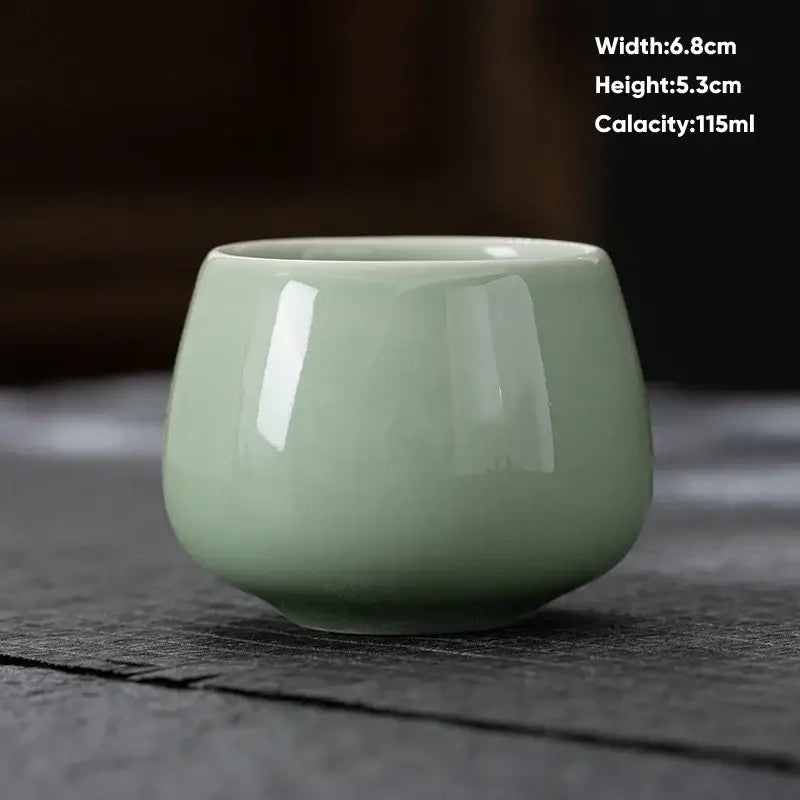 A smooth light green ceramic kungfu tea cup with a glossy finish from decorbites ceramic kungfu tea set