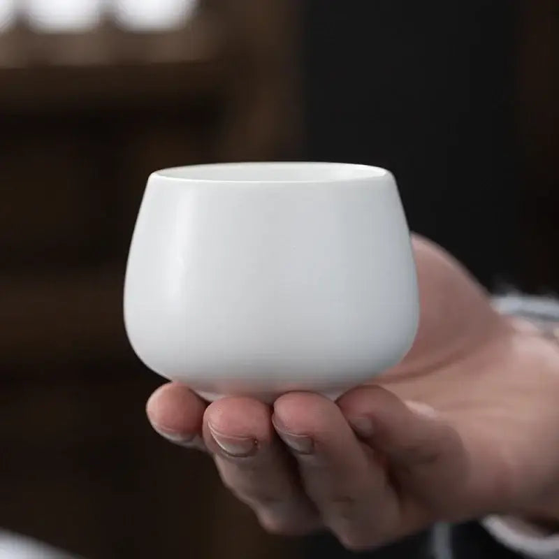 A smooth white ceramic kungfu tea cup with a rounded flared rim from decorbites ceramic kungfu set for dining room use