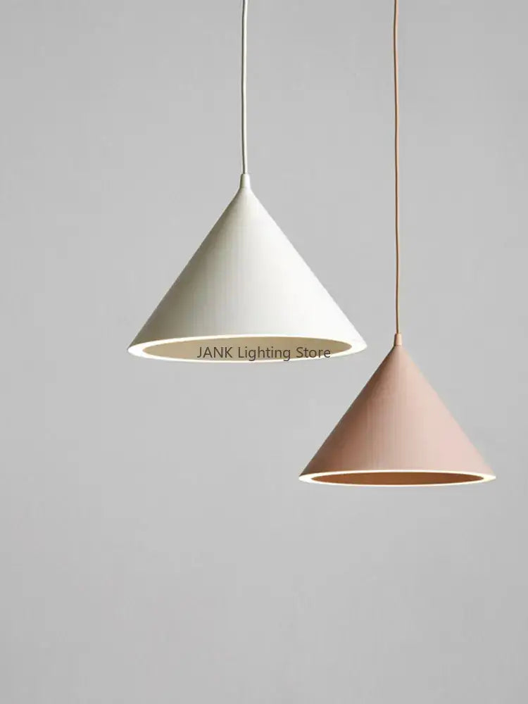 Two minimalist matte white and blush pink decorbites cone shape pendant lights showcasing modern lighting methods