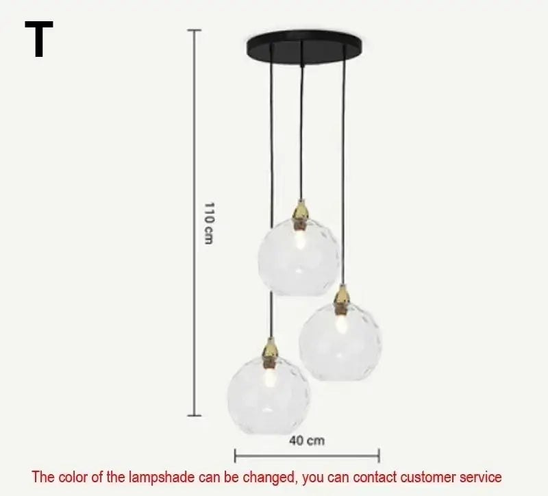 Modern three-light pendant light with clear faceted glass globes and brass fittings on black mount in polished chrome design