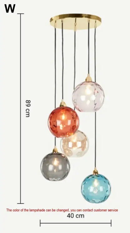 A modern pendant light with five colorful textured glass globes and polished chrome mount for dining room use