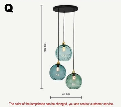 A modern pendant light with three teal textured glass globes and black metal hardware in polished chrome finish