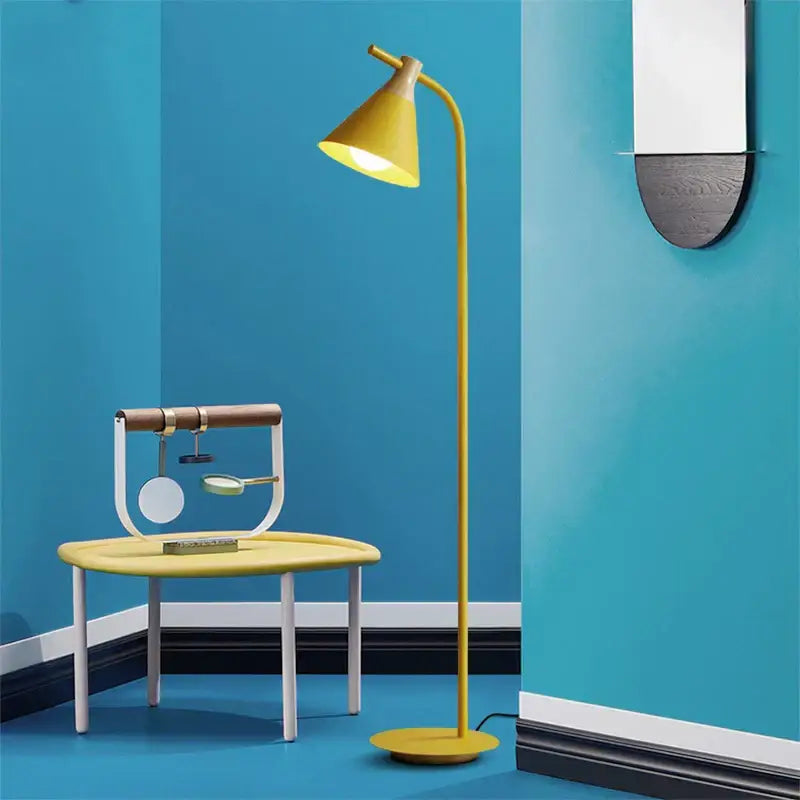 Yellow conical iron macaron floor lamp with slender curved stem and circular base for modern living room decorbites iron macaron floor