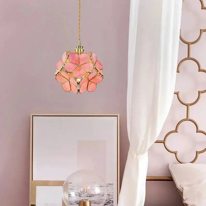A delicate pink floral pendant light with gold-toned metal accents and woven cord for decorbites colorful glass led lighting