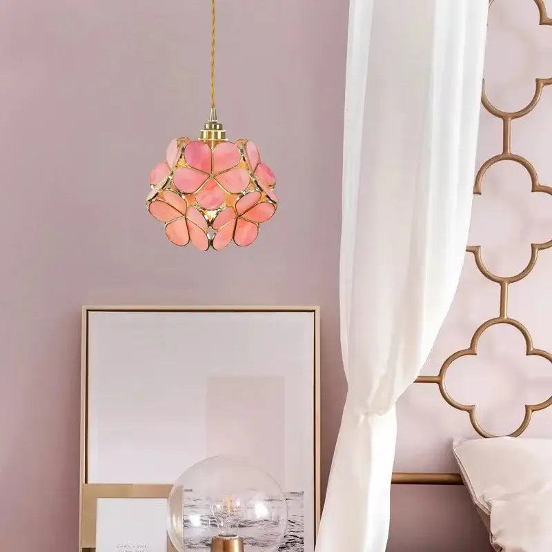 A delicate pink floral pendant light with gold-toned metal accents and woven cord for decorbites colorful glass led lighting