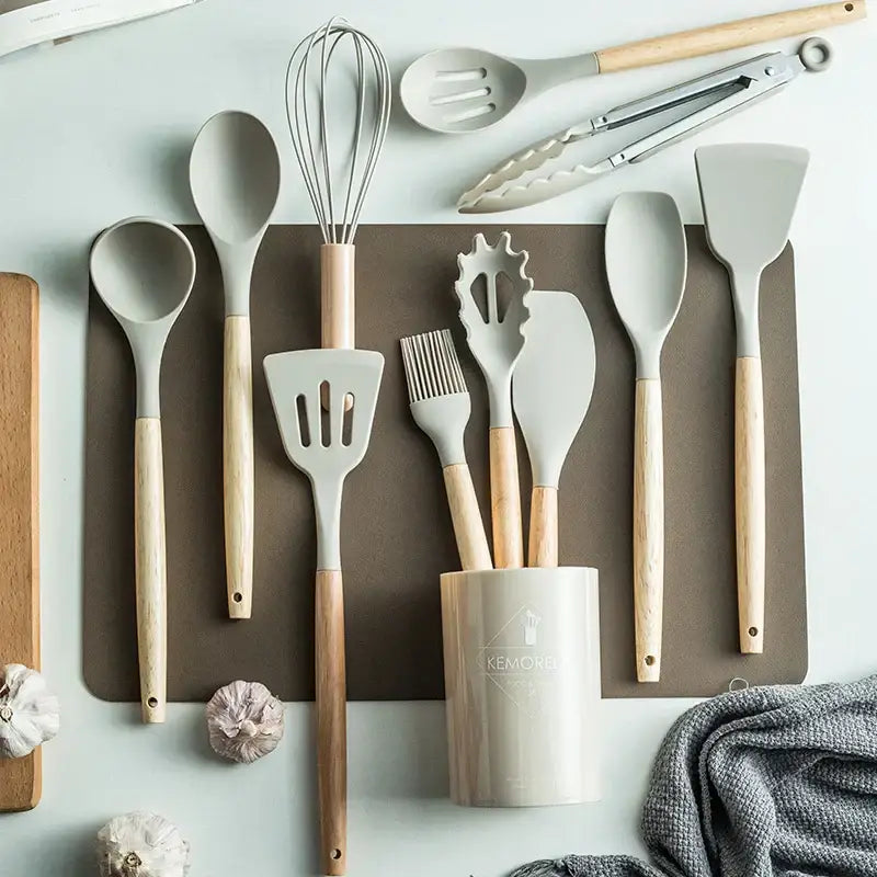 Modern pastel silicone kitchen utensil set with light gray silicone-coated wooden handles and matching storage cup