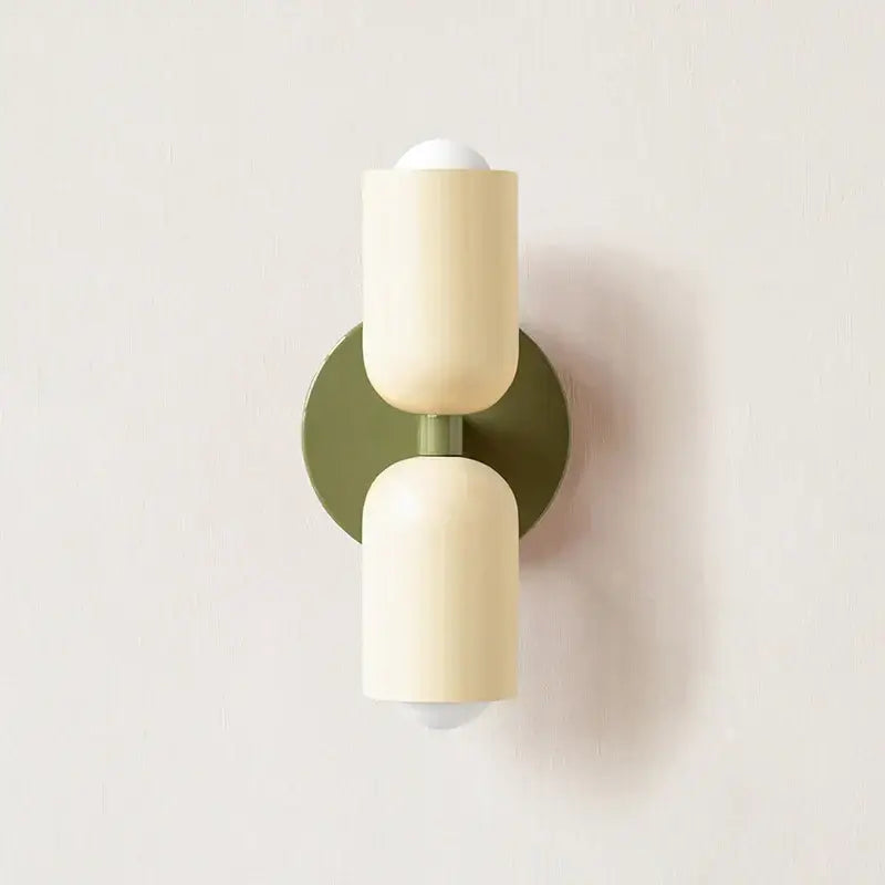 Cream-colored cylindrical decorbites led wall sconce with matte finish and olive green backplate for modern led wall lights