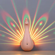 Modern peach peacock wall sconce with glossy finish projecting vibrant rainbow patterns for bedroom lighting