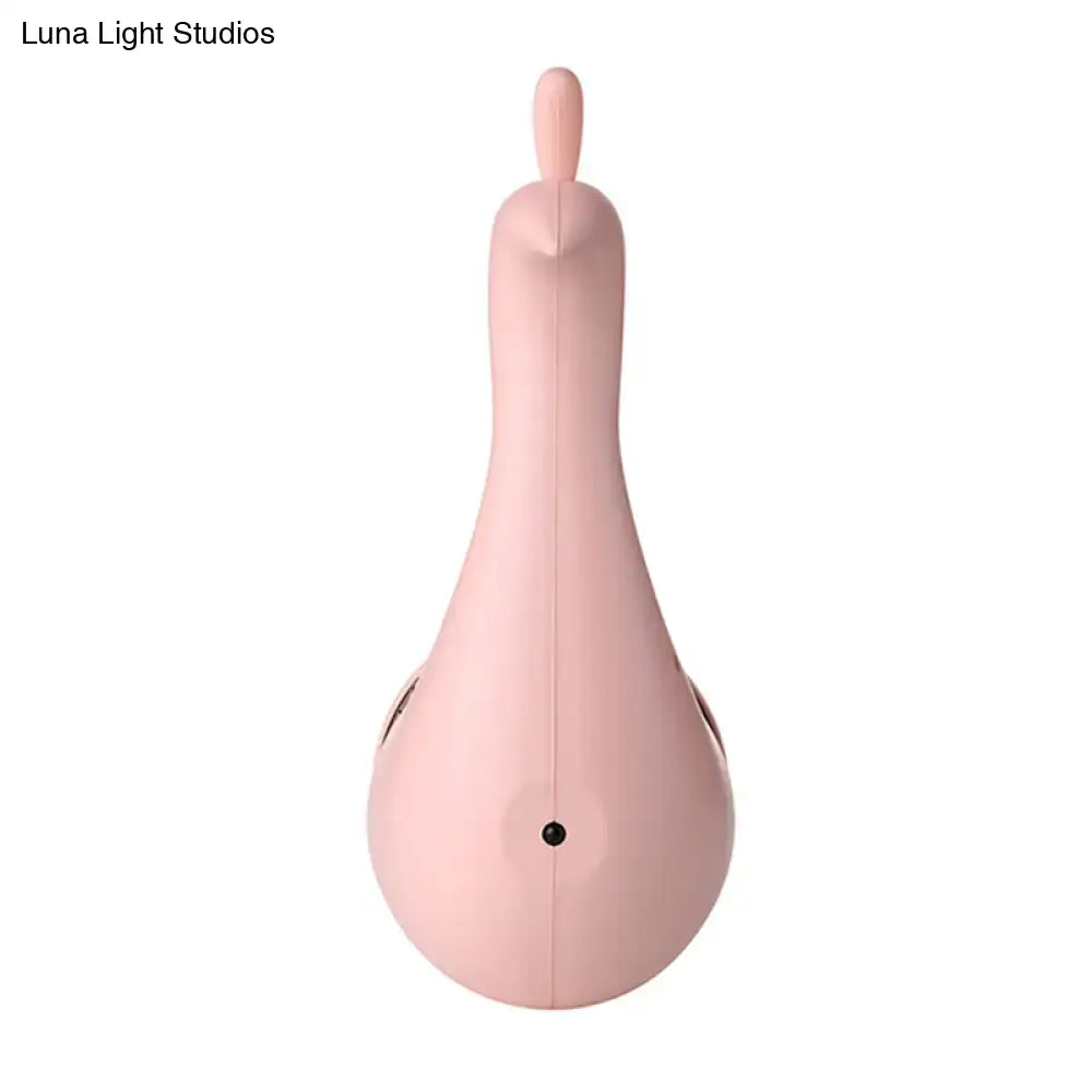 A sleek matte pink silicone modern peach peacock wall sconce with rounded body and top handle for bedroom rainbow projection