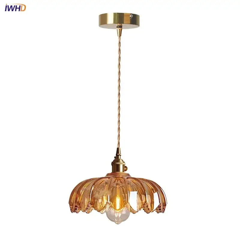 Gold-toned pendant lamp with amber glass led petal-shaped shade and twisted brass cable for dining room lighting