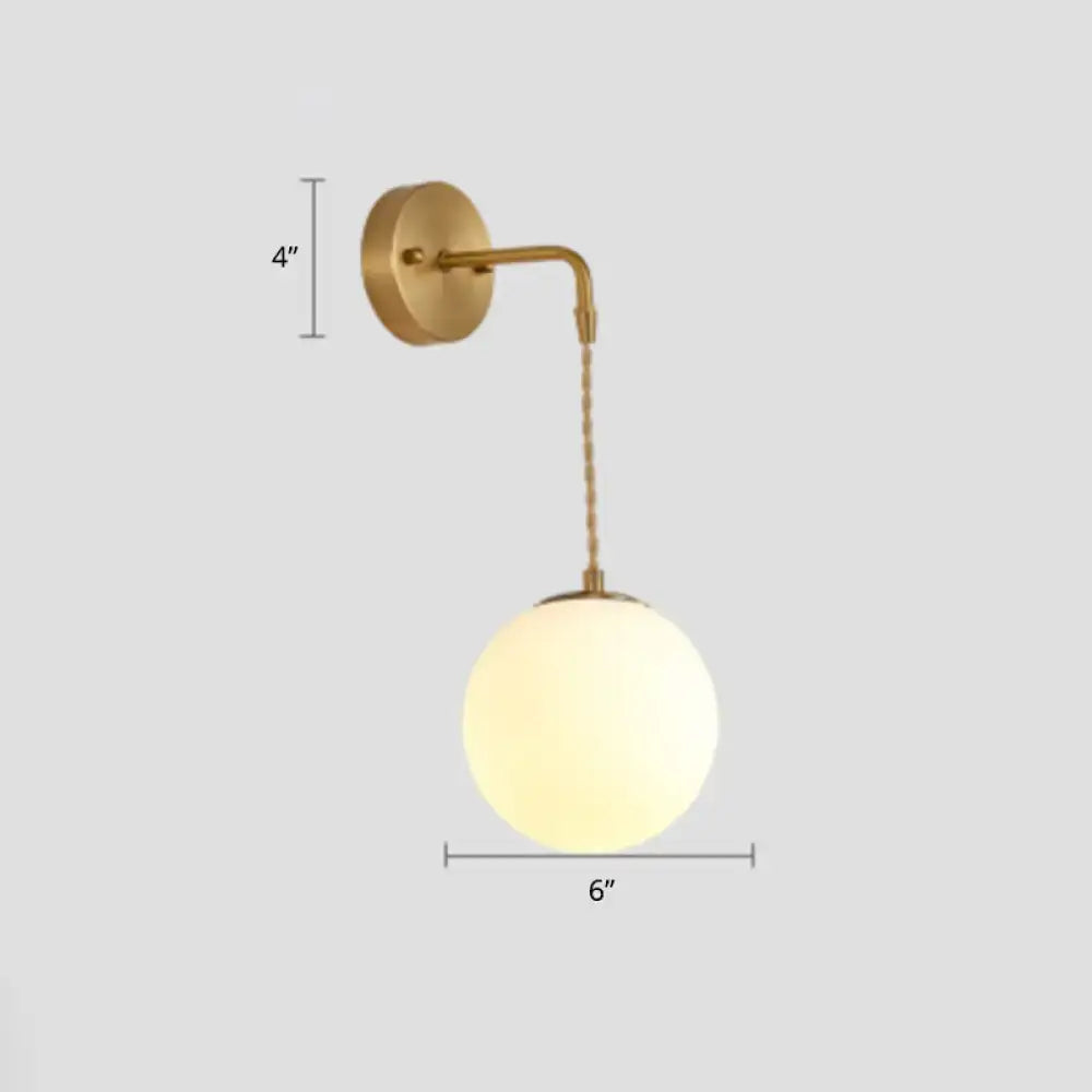 Gold-toned wall sconce with spherical frosted glass globe and curved metal arm for bedside reading e14 e26 e27 bulbs