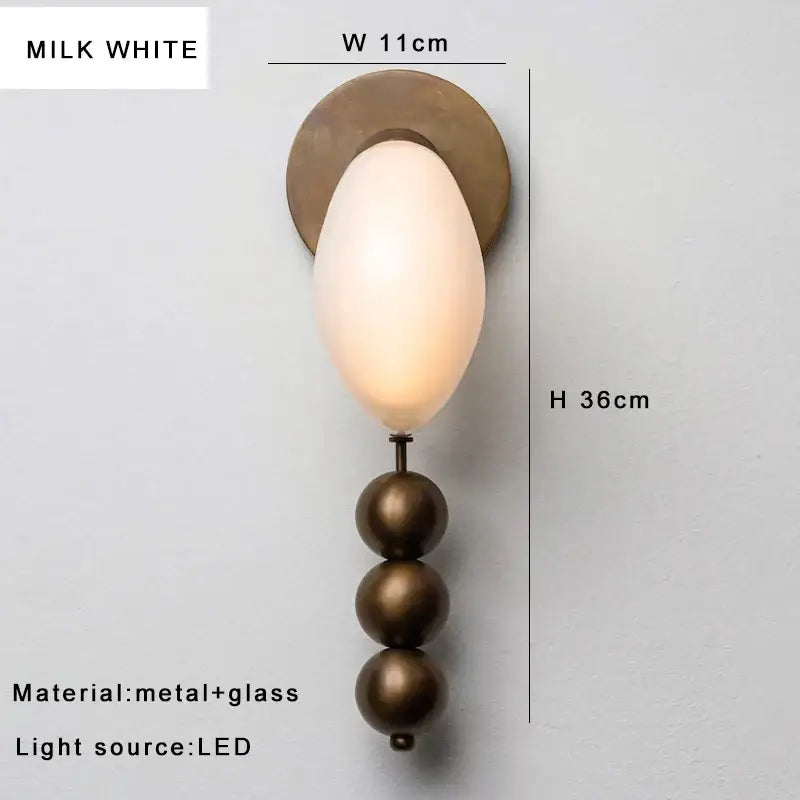 Milk white oval glass wall lamp with bronze base and brass curve glass accents featuring an led light source
