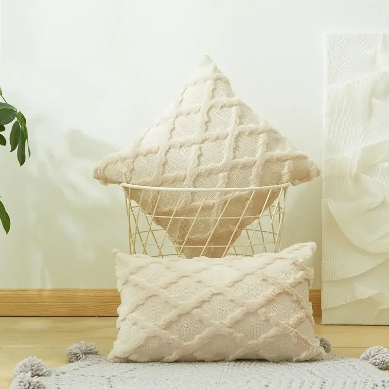 Cream-colored textured knit throw pillows with diamond embroidery cushion cover and tassel trim for living room use