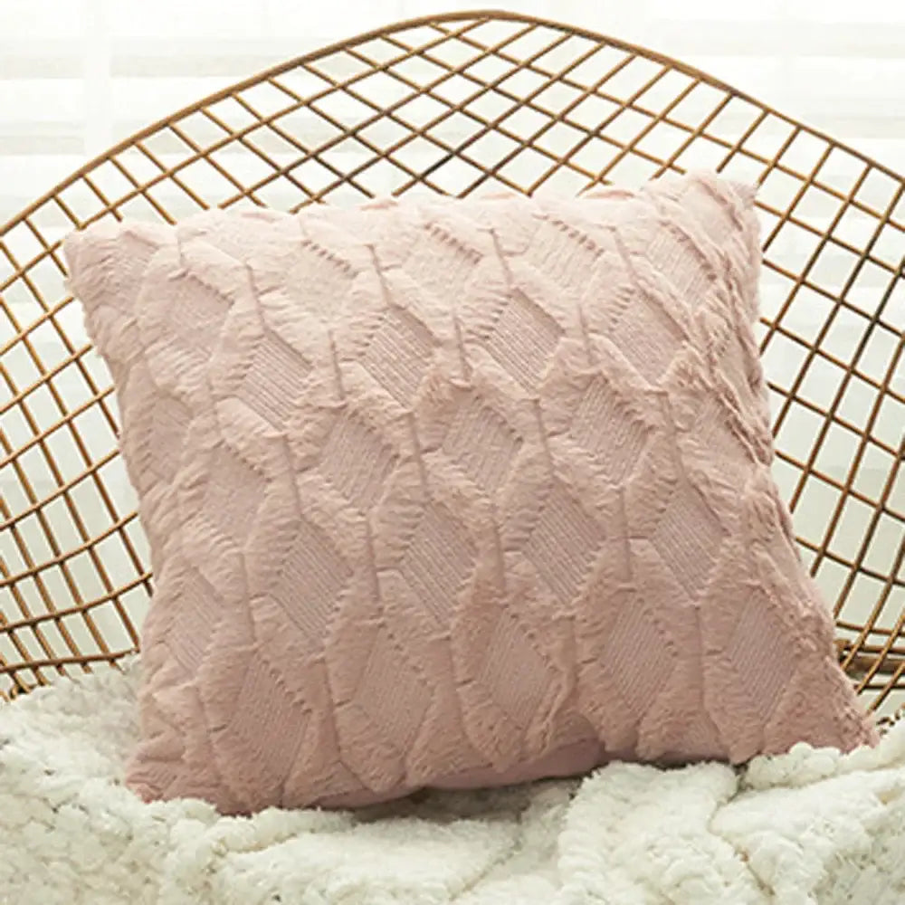 A soft pink cushion cover with diamond embroidery and textured knit design on a white fluffy surface for living room