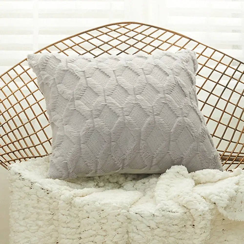 A soft off-white cushion cover with textured diamond embroidery sits on a wire chair for modern living room use