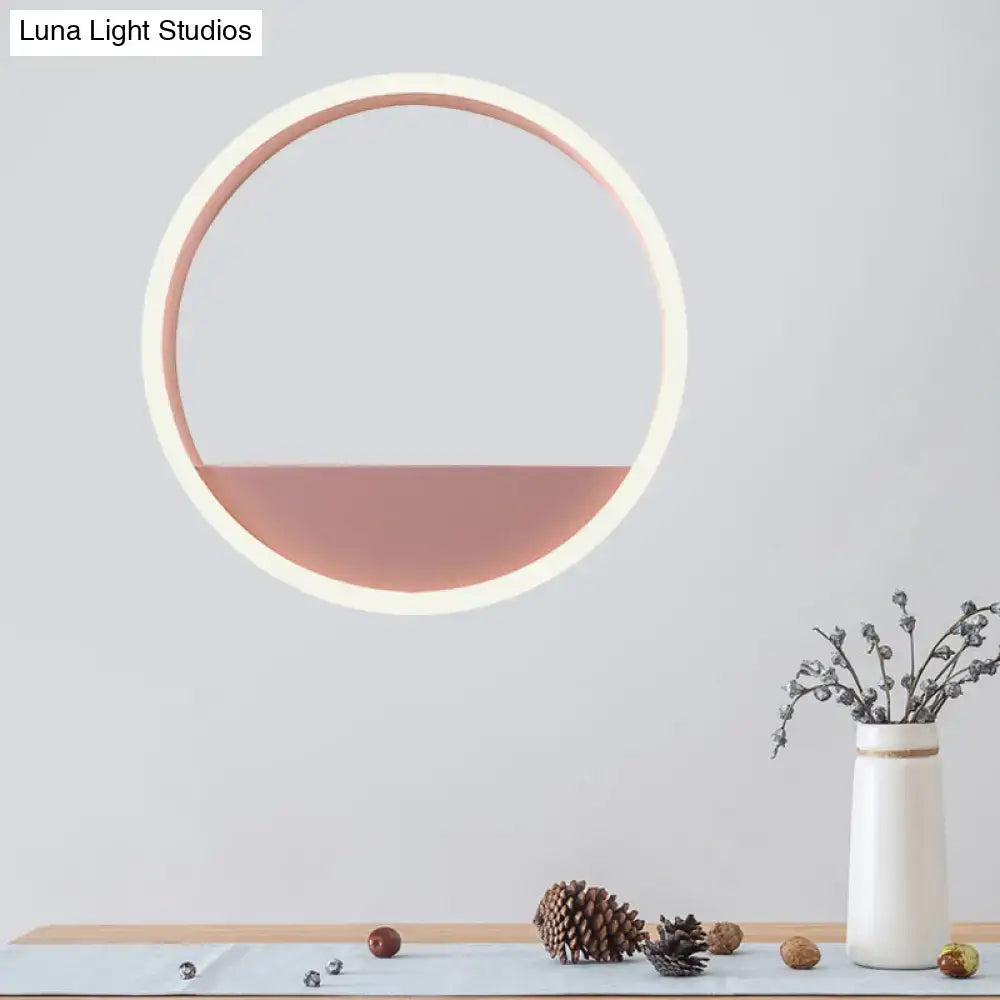 Modern pink and blue iron hoop wall light with circular white frame and soft rose gold illuminated lower half for bedroom use