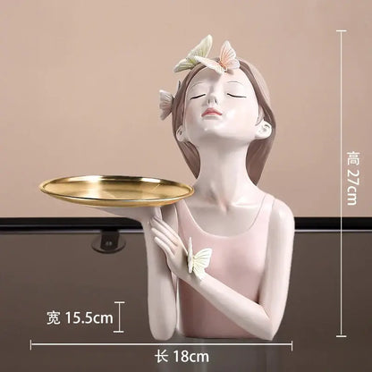 A delicate pink butterfly girl resin figure holding a gold tray with white and peach butterflies for living room decor