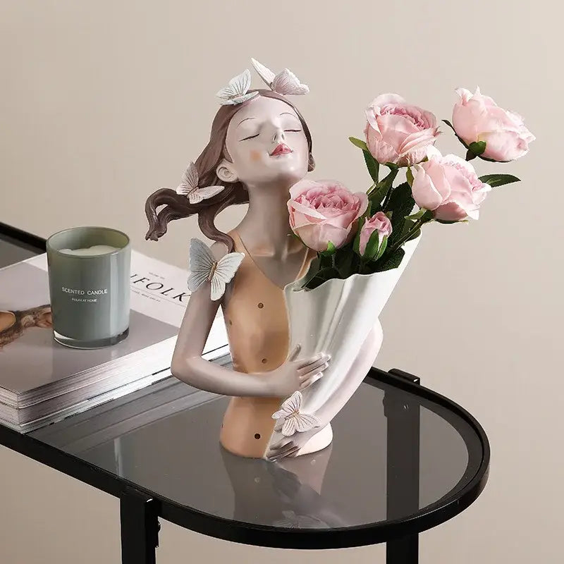 A porcelain resin butterfly girl sculpture in pink holding roses with delicate white butterfly accents for living room decor