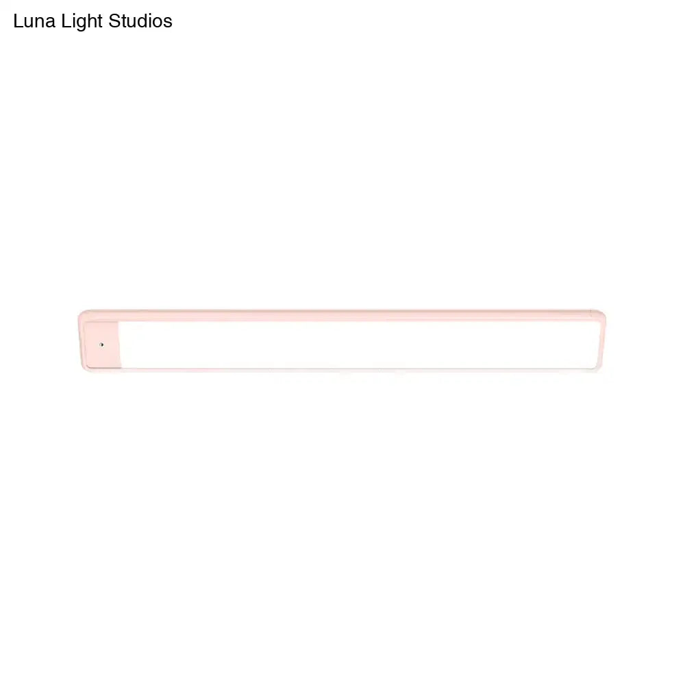 Modern pink elongated vanity lighting fixture with a sleek plastic frame and bright white illuminated surface for bedroom