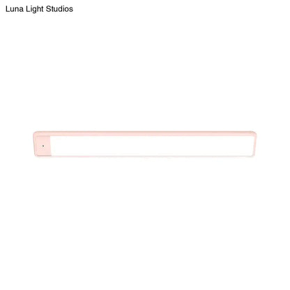 Modern pink elongated vanity lighting fixture with a sleek plastic frame and bright white illuminated surface for bedroom