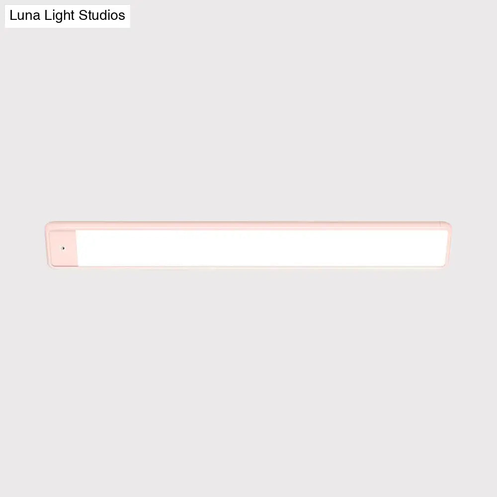 Modern pink elongated vanity lighting fixture with sleek white illuminated surface and plastic elongated vanity frame