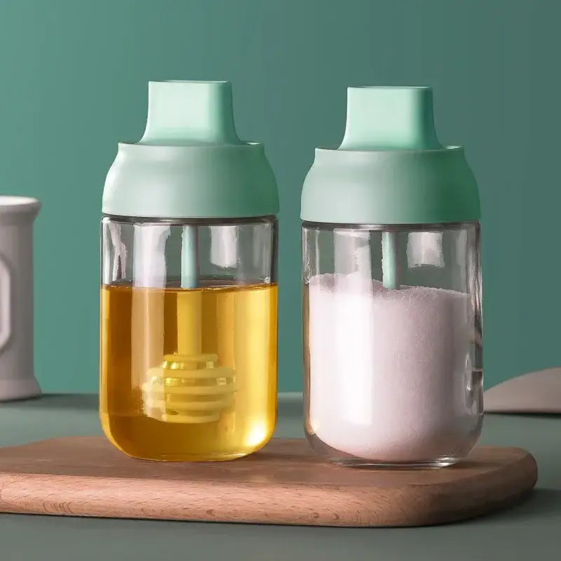 Two clear glass seasoning bottles with mint green lids holding honey and sugar in modern pink glass seasoning bottle set
