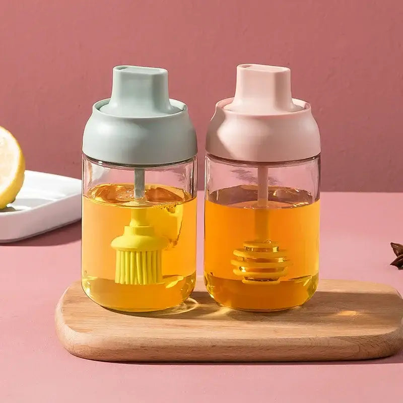 Modern pink glass seasoning bottle set with two clear glass seasoning bottles featuring pastel lids and built-in dippers