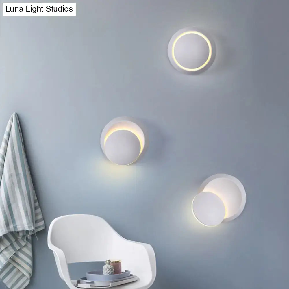 Modern circular wall sconces with a sleek white finish and warm, glowing led rings.