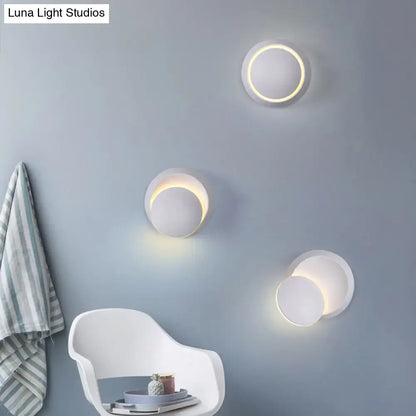 Modern circular wall sconces with a sleek white finish and warm, glowing led rings.