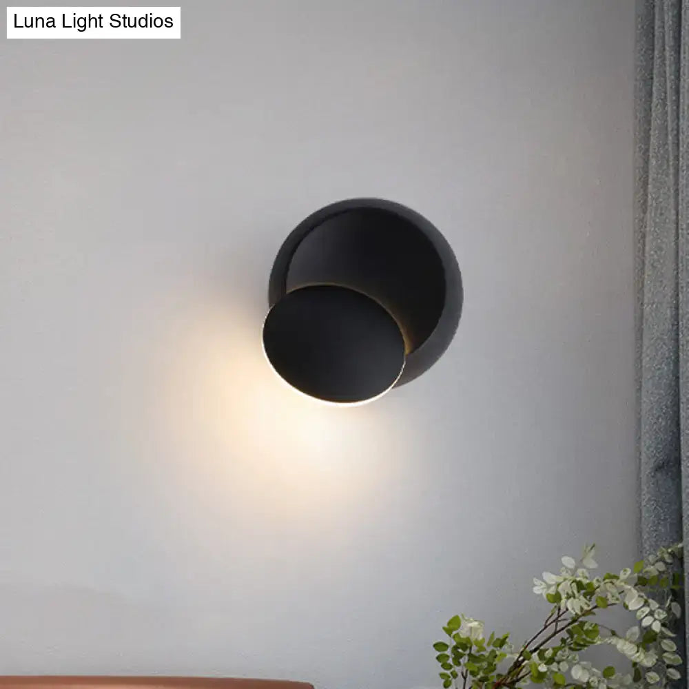 Black matte-finished wall sconce with a modern, minimalist design featuring two concentric circular elements.