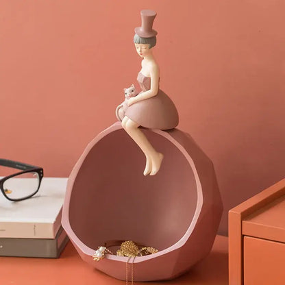 Modern pink and gray geometric sculpture tray with an elegant woman figurine holding a cat for home decor by decorbites