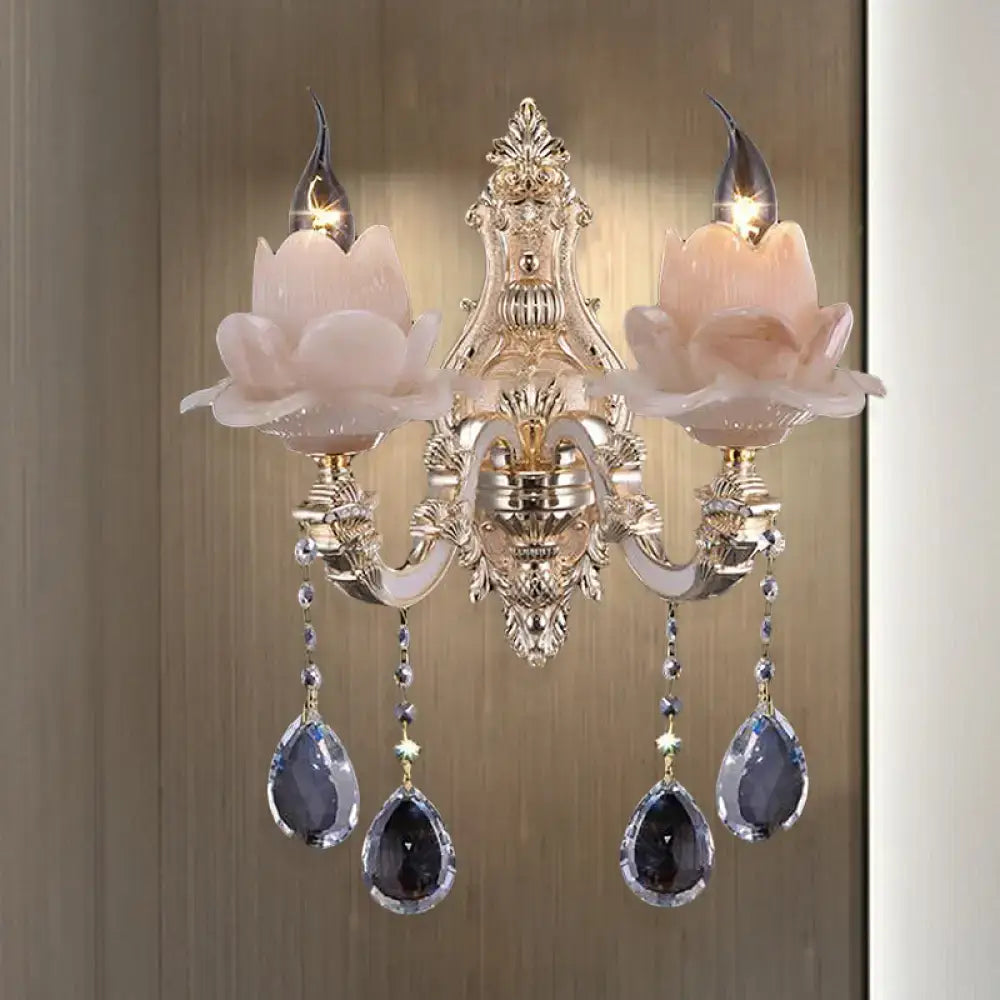 Elegant gold-toned wall lamp with milky glass pink lotus flower shades and teardrop crystal pendants for bedroom use