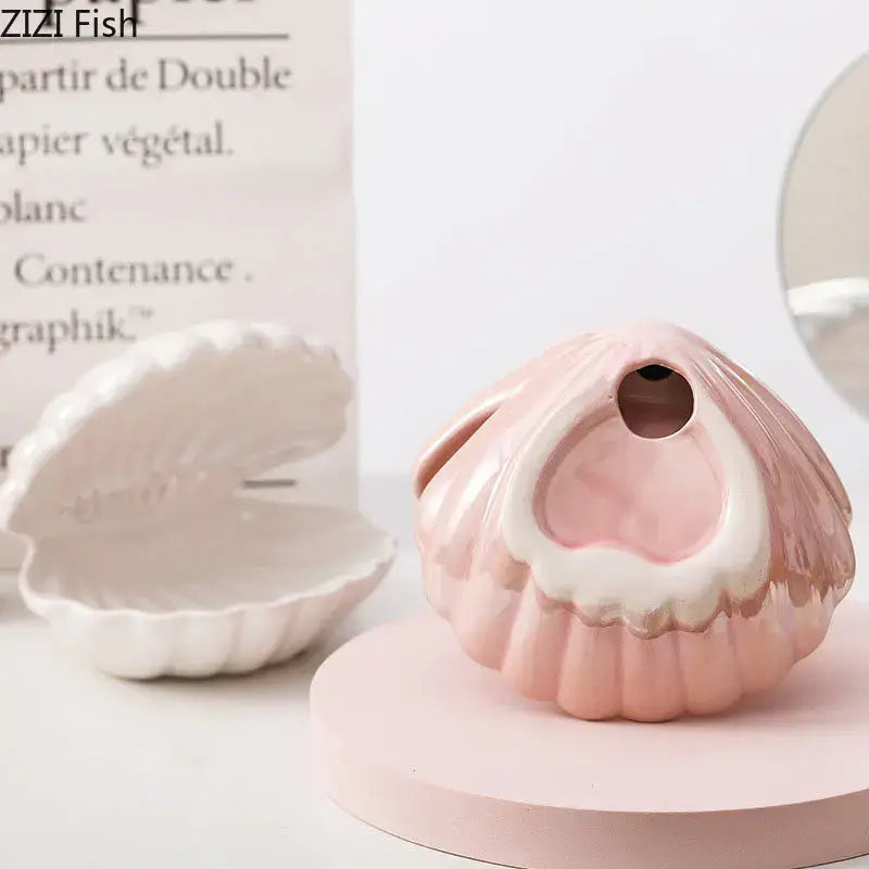A delicate pink ceramic seashell-shaped planter with glossy finish and white interior as modern lamp desk decoration