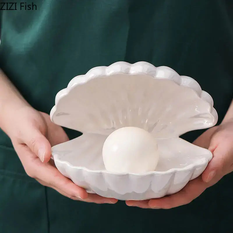 Modern pink and off-white pearl shell lamp desk decoration featuring a white ceramic clamshell dish with pearl sphere